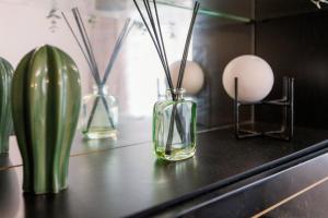cztery szklane wazy z kijami na stole w obiekcie Home near Excel, Stratford and Canary Wharf w Londynie