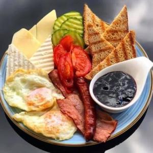 a plate of breakfast food with eggs bacon toast and dips at B&B Apartment in Oţelu Roşu