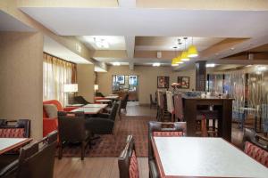 a restaurant with tables and chairs and a bar at Hampton Inn St. Louis/Collinsville in Collinsville