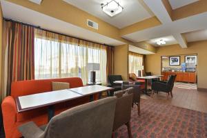 a waiting room with chairs and tables in a hotel room at Hampton Inn St. Louis/Collinsville in Collinsville