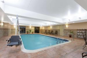 una gran piscina en una habitación de hotel con una silla en Hampton Inn & Suites Albany-Airport, en Latham