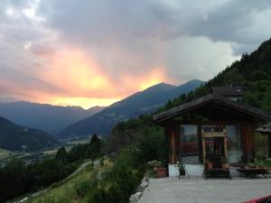 a building on a hill with a rainbow in the sky at Panoramahof Holly in Obervellach