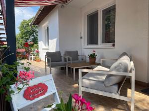 un patio con sofás, mesa y sillas en Vizililiom Vendégház, en Tiszafüred