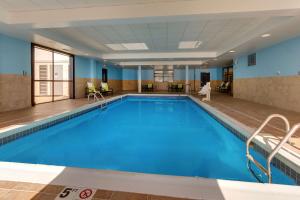 uma grande piscina com água azul num quarto de hotel em Hampton Inn Springfield em Springfield