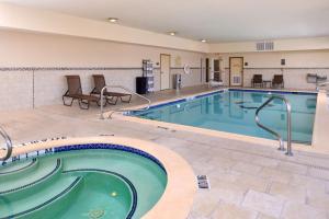 a pool in a hotel with chairs and a table at Hampton Inn Van Horn in Van Horn