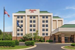 een hotel met een Amerikaanse vlag ervoor bij Hampton Inn Dulles/Cascades in Sterling