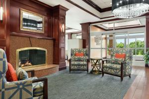Hampton Inn Dulles/Cascades في ستيرلينغ: غرفة معيشة بها موقد وكراسي