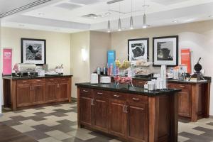 una habitación con armarios de madera y una barra en una tienda en Hampton Inn Columbus/South-Fort Benning, en Columbus