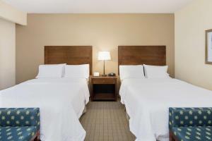 a hotel room with two beds and two chairs at Hampton Inn Columbus/South-Fort Benning in Columbus