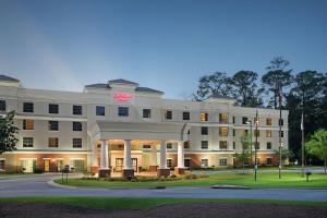 um grande edifício branco com um sinal rosa em Hampton Inn Columbus/South-Fort Benning em Columbus