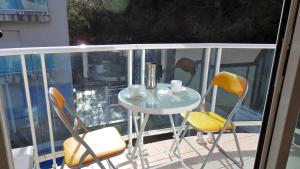 een kleine tafel en stoelen op een balkon bij MEDDAYS APARTAMENTO AZUL in Miami Platja