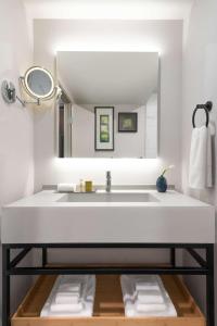 W łazience znajduje się biała umywalka i lustro. w obiekcie DoubleTree by Hilton San Francisco South Airport Blvd w mieście South San Francisco