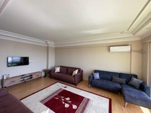 a living room with two couches and a tv at Liman House Akçakale in Akcaabat