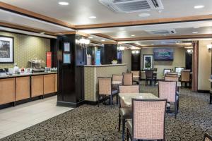 a restaurant with a bar and tables and chairs at Hampton Inn & Suites Montgomery-Downtown in Montgomery