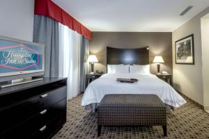 Hampton Inn & Suites Montgomery-Downtown في مونتغومري: غرفة فندقية بسرير وتلفزيون بشاشة مسطحة