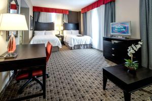 Hampton Inn & Suites Montgomery-Downtown في مونتغومري: غرفة فندقية بسريرين ومكتب