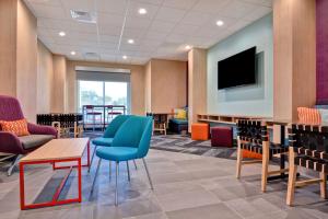 a waiting room with chairs and a flat screen tv at Tru By Hilton St. Petersburg Downtown Central Ave in St. Petersburg