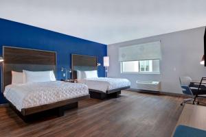 um quarto de hotel com duas camas e uma parede azul em Tru By Hilton St. Petersburg Downtown Central Ave em St. Petersburg