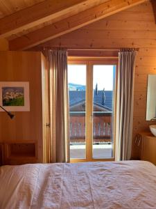 a bedroom with a bed and a large window at Les Majis 20 in Champoussin