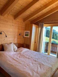 a bedroom with a bed with a large window at Les Majis 20 in Champoussin