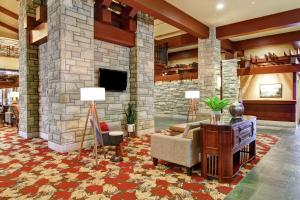 a living room with a stone fireplace with a couch and a chair at DoubleTree Fallsview Resort & Spa by Hilton - Niagara Falls in Niagara Falls