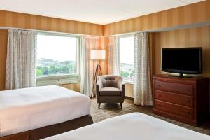 una camera d'albergo con letto, TV e sedia di DoubleTree Fallsview Resort & Spa by Hilton - Niagara Falls a Niagara Falls