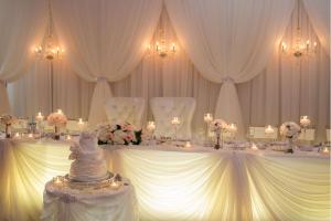 a table with white chairs and a wedding cake on it at DoubleTree Fallsview Resort & Spa by Hilton - Niagara Falls in Niagara Falls
