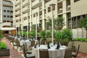 a row of tables and chairs in the courtyard of a building at Embassy Suites by Hilton Atlanta at Centennial Olympic Park in Atlanta