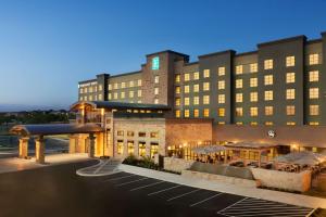 um hotel com um parque de estacionamento em frente em Embassy Suites San Antonio Brooks City Base Hotel & Spa em San Antonio