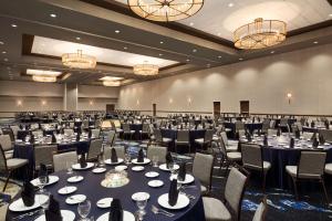einen Bankettsaal mit Tischen, Stühlen und Kronleuchtern in der Unterkunft Embassy Suites San Antonio Brooks City Base Hotel & Spa in San Antonio