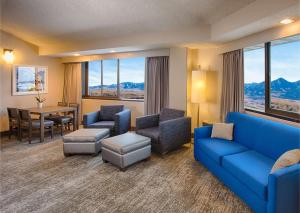 a living room with a blue couch and chairs and a table at DoubleTree by Hilton Denver/Westminister in Westminster