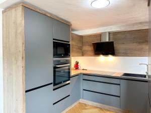 a kitchen with white and gray cabinets and a sink at LUX residence, A/C, VIP parking, city view in Banská Bystrica