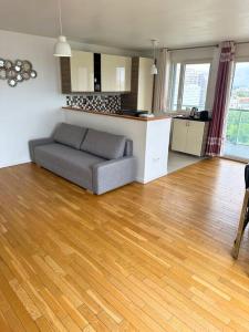 a living room with a couch and a wooden floor at Magnifique Appart. spacieux 8P/ Défense-Courbevoie in Courbevoie