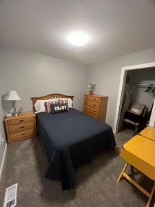 um quarto com uma cama, uma secretária e um espelho em Charming and Happy Walled Lake MI Cottage em Novi