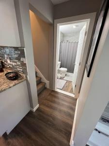 um corredor com uma casa de banho com WC e uma escada em Charming and Happy Walled Lake MI Cottage em Novi