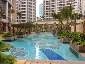 een zwembad in het midden van een gebouw met palmbomen bij Condo private Lift in Jakarta