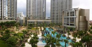 een resort met een zwembad en palmbomen en gebouwen bij Condo private Lift in Jakarta