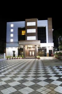 a building at night with a tiled courtyard in front at Rydges Inn in Kottakkal