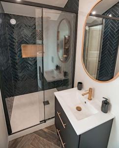 y baño con ducha, lavabo y espejo. en Bel appartement neuf, central, terrasse, clim, en Le Plan-de-la-Tour
