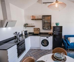 eine Küche mit Waschmaschine und Trockner im Zimmer in der Unterkunft Bel appartement neuf, central, terrasse, clim in Plan-de-la-Tour
