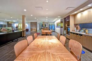 欧克莱尔Home2 Suites Eau Claire South, Wi的带厨房的客房内一张大木桌