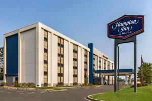 een groot wit gebouw met een bord ervoor bij Hampton Inn Chicago-O'Hare International Airport in Schiller Park