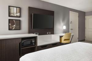 a hotel room with a desk and a tv on a wall at Hampton Inn Chicago-O'Hare International Airport in Schiller Park