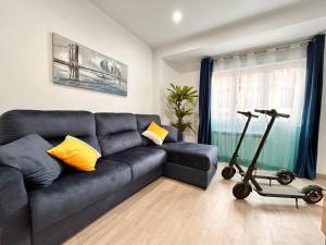 uma sala de estar com um sofá azul e uma passadeira em LUJO: Proyector, Maquina Arcade, Wifi y Patinetes em Oviedo