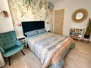 um quarto com uma cama e uma cadeira azul em LUJO: Proyector, Maquina Arcade, Wifi y Patinetes em Oviedo