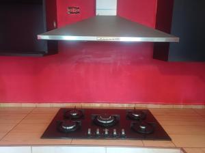płyta kuchenna w kuchni z czerwoną ścianą w obiekcie Departamento amoblado amplio w mieście Huancayo