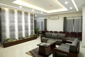 a waiting room with a couch and chairs at Rydges Inn in Kottakkal