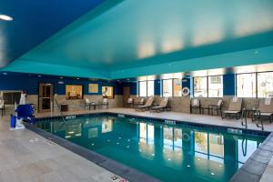 una piscina con sillas y mesas en un edificio en Hampton Inn & Suites Aurora South, Co en Aurora