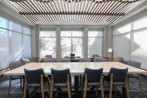 Hilton Garden Inn Melville في بلاينفيو: قاعة اجتماعات مع طاولة وكراسي كبيرة