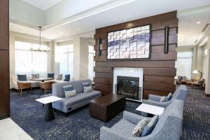 a living room with two couches and a fireplace at Hilton Garden Inn Melville in Plainview